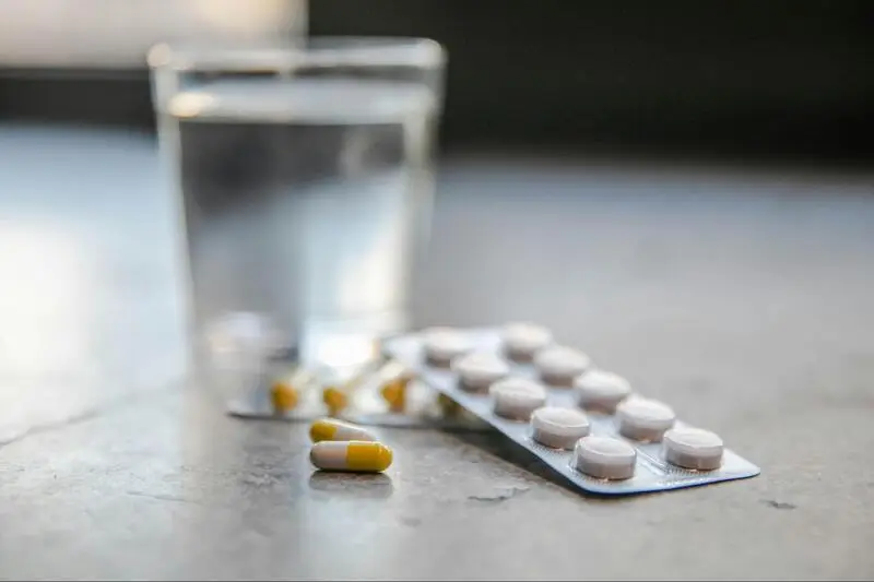 Pills next to a glass of water