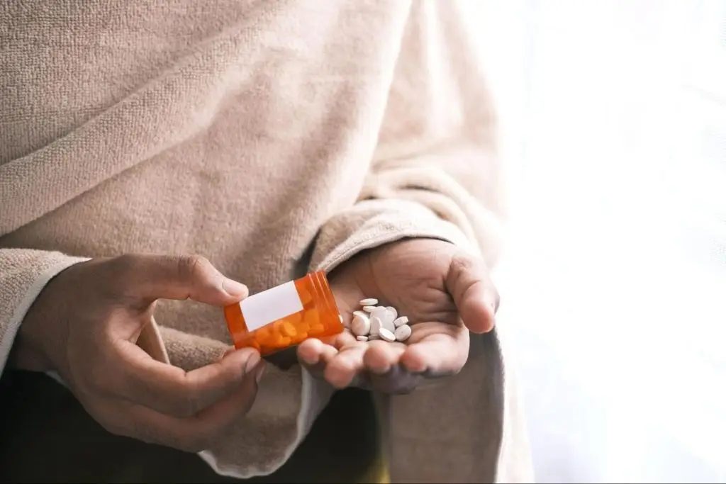 a person putting pills in their palm