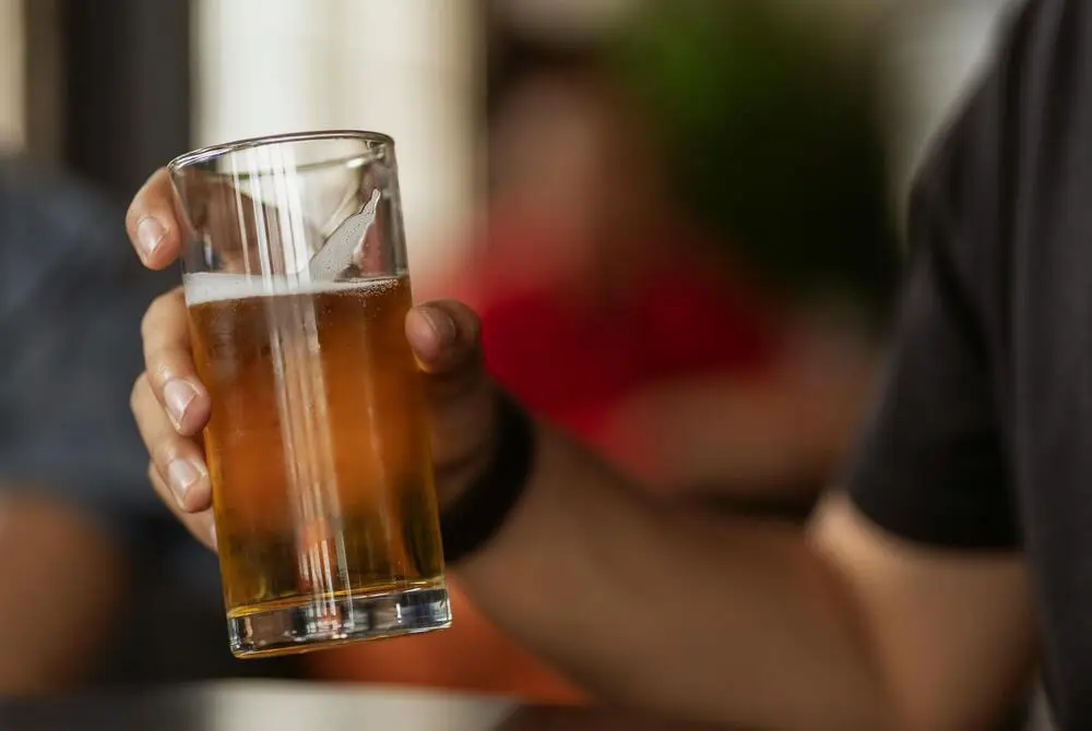 man holding a glass of bier