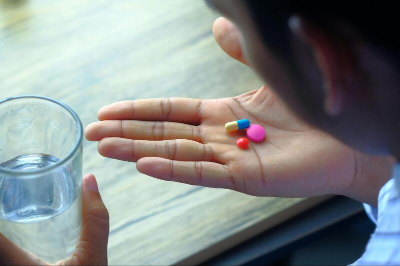 Man taking his meds with a glass of water