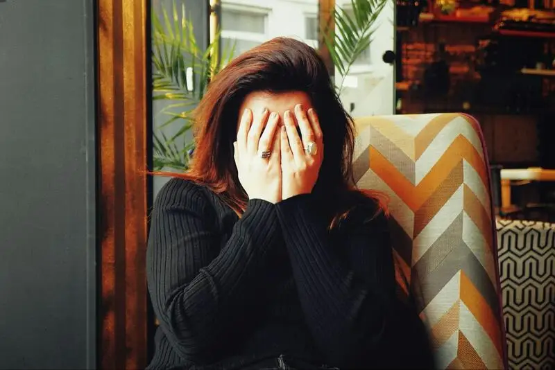 Woman covering her face, showing signs of distress