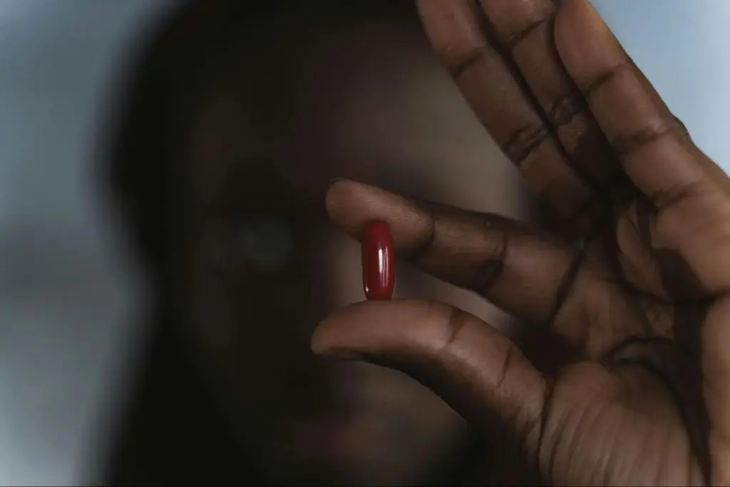 A man holding a red pill