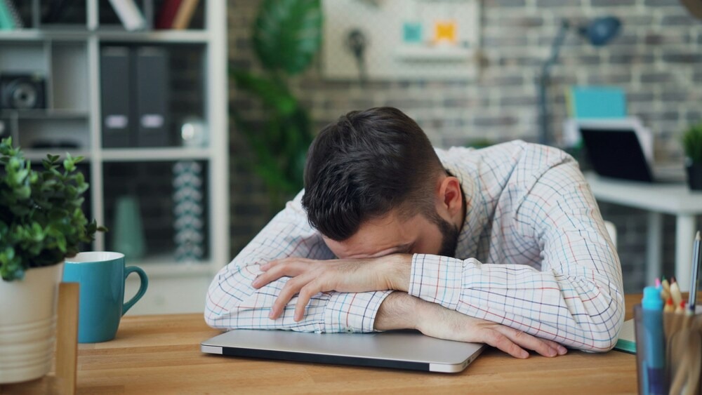 Man feeling drowsy at work due to medication